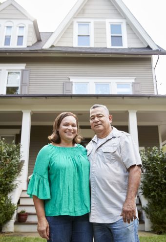 portrait-of-smiling-senior-couple-in-front-of-thei-2024-10-19-07-16-51-utc (1)